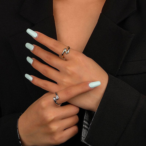 A woman wearing a black jacket and a pair of Tizzarat Sliver Hug Rings she bought online.	